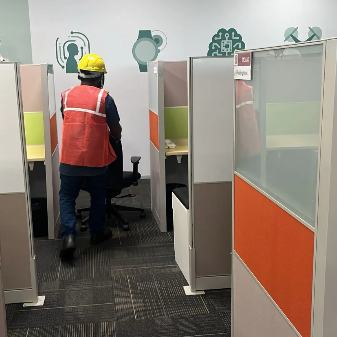 Deconstruction technicians dismantling complex modular workspace components cleanly inside an IT corridor block in Taramani Chennai.