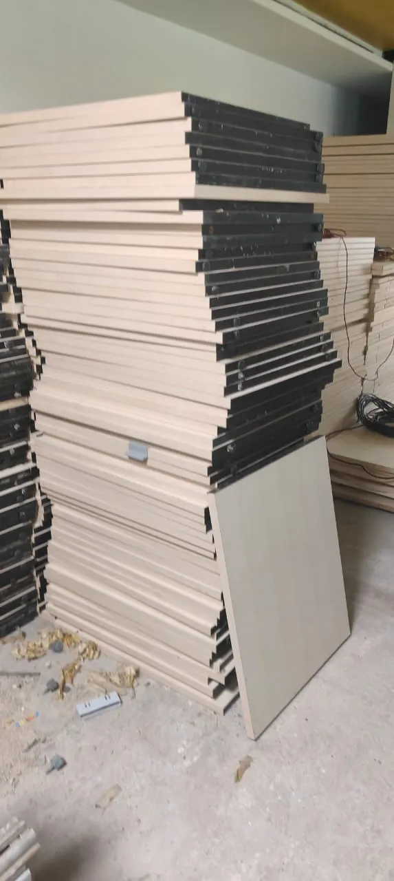Disassembled corporate workspace desks stored flat-packed during an office furniture dismantling Taramani project run.